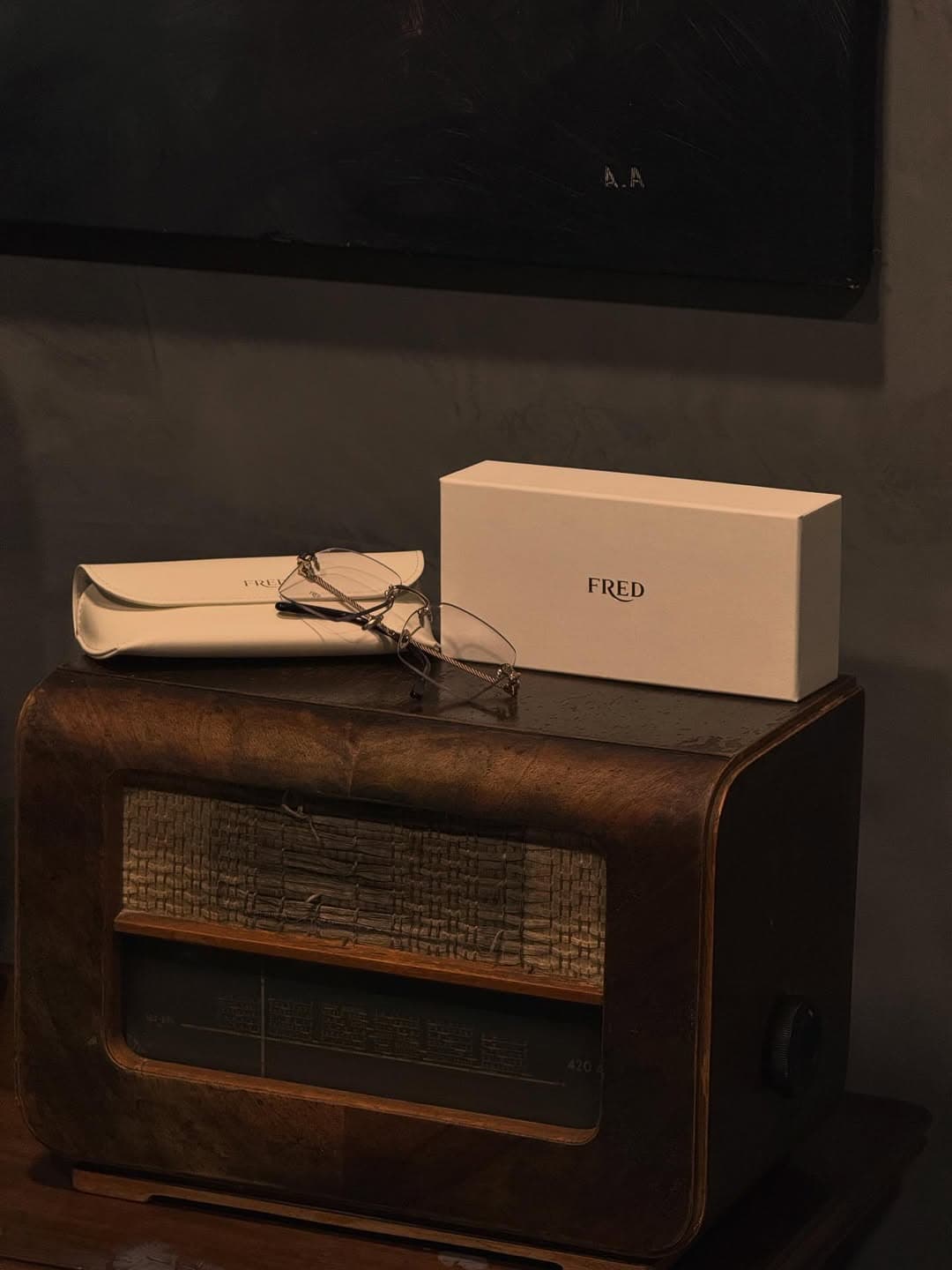 Fine eyewear and protective case set on a crafted wooden trunk